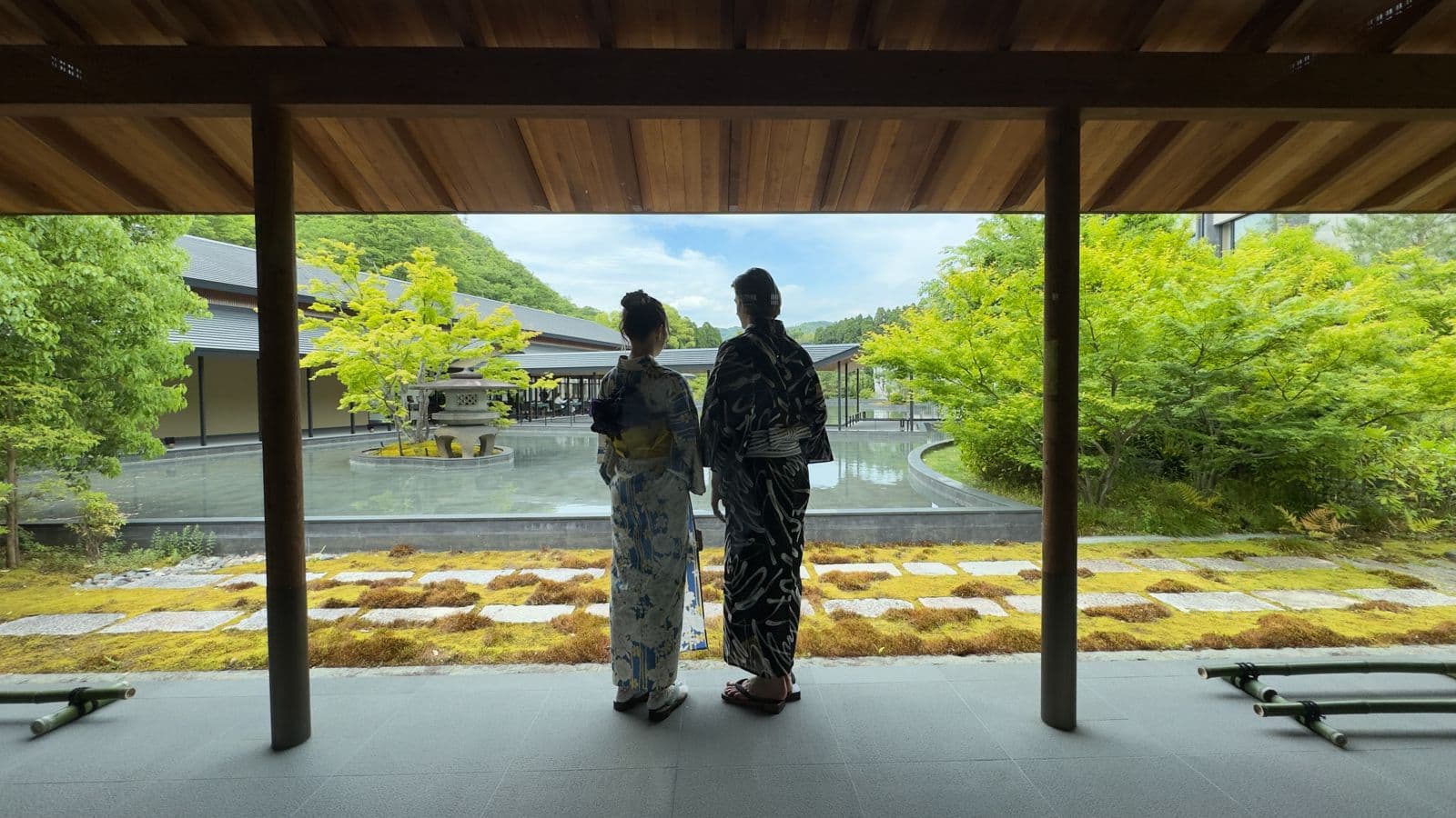Two guests in yukata looking out over a Kyoto garden