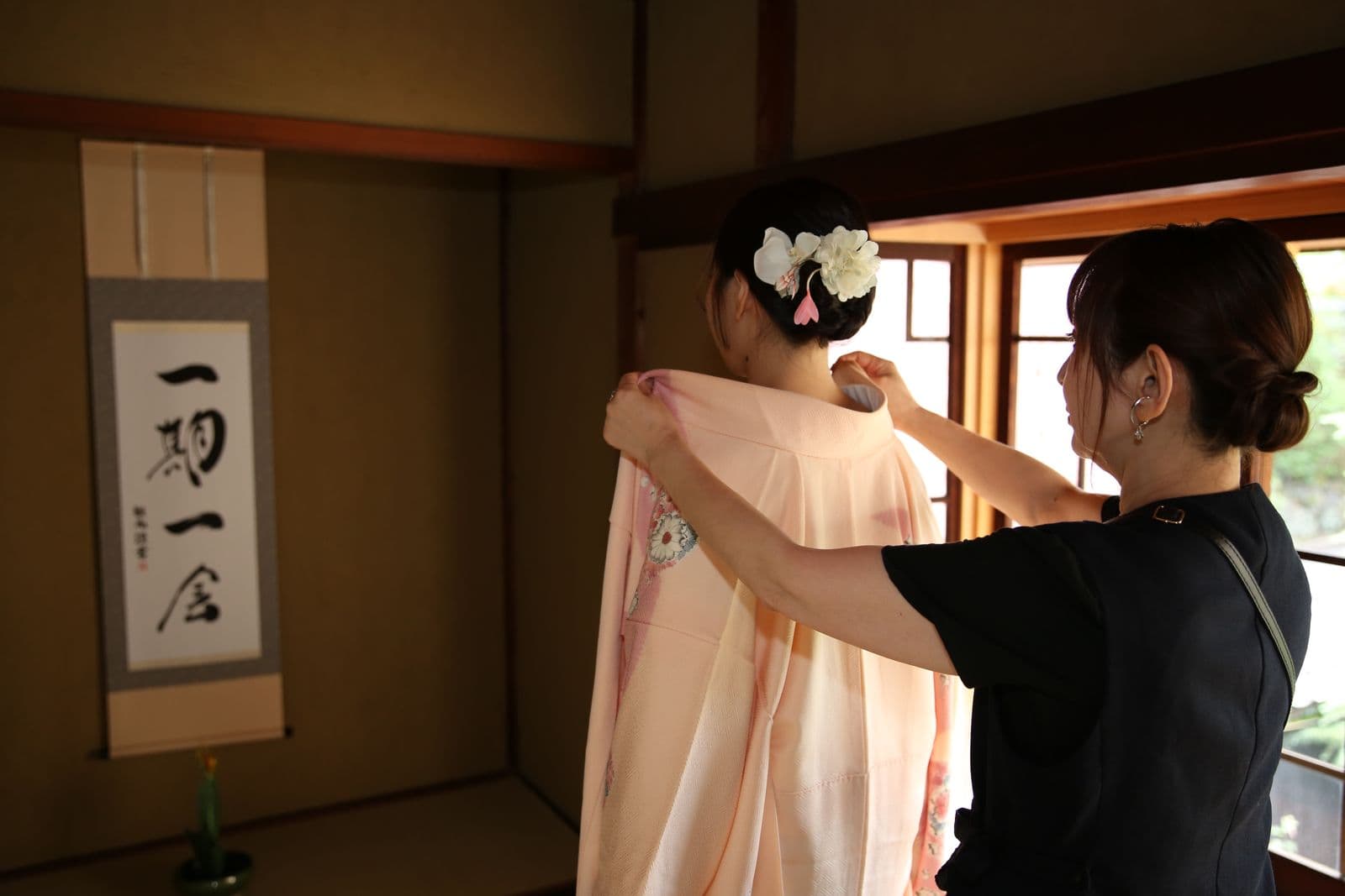 Instructor draping the kimono over the guest