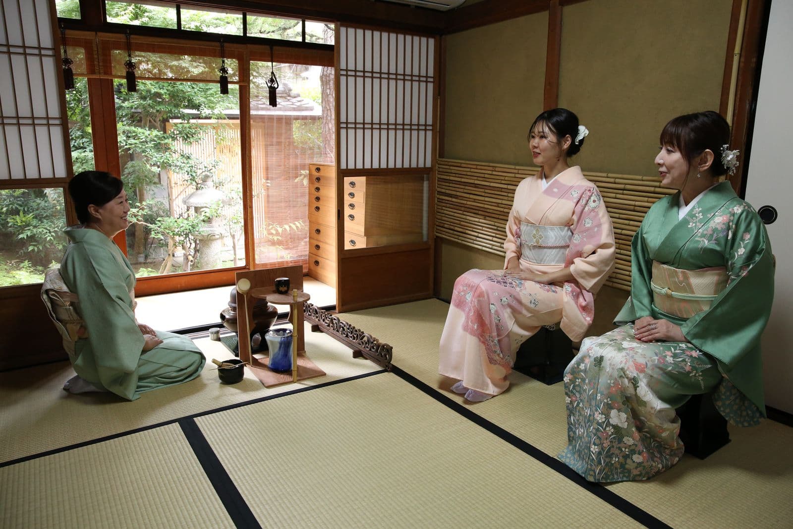 Guests in kimono watching the tea preparation